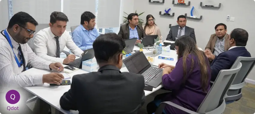 Qdot professional team discussing ISO 9001 quality management strategies during an internal meeting